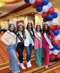 a group of women posing for a photo in front of balloons
