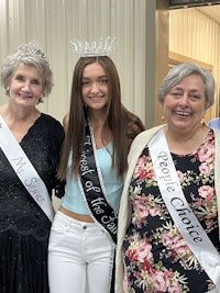 three women posing for a picture with a sash
